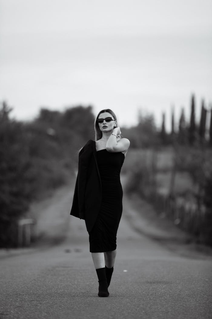 services-01 Elegant woman in a black dress posing stylishly on a country road, perfect for fashion editorials.