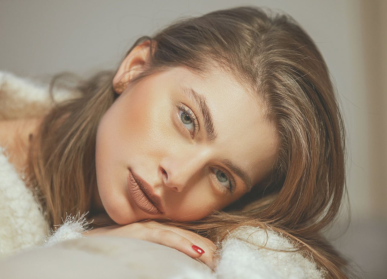 gallery-01 Close-up portrait of a woman resting her head, showcasing elegant features and soft lighting.